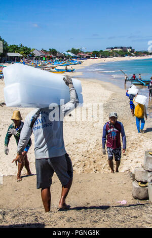 Bali, Indonesia - 30 Maggio 2017: Uomini di ghiaccio di caricamento su una barca da pesca. Il ghiaccio è usato per mantenere la cattura cool. Foto Stock