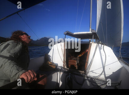 Sailor controllo vela sul piccolo yacht, Hinchinbrook Channel, Queensland, Australia. No signor o PR Foto Stock