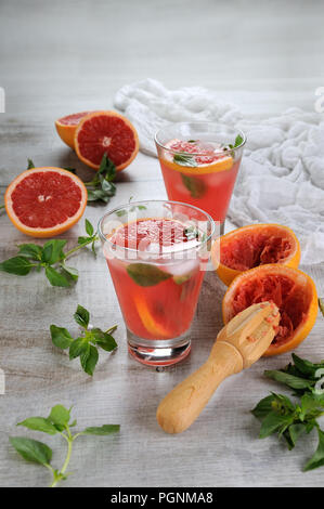 Cocktail di succhi di frutta e spremuta di pompelmo rosso e foglie di basilico delicato limone. Che cosa ci potrebbe essere di meglio in un pilotabili, caldo giorno di sole? Foto Stock