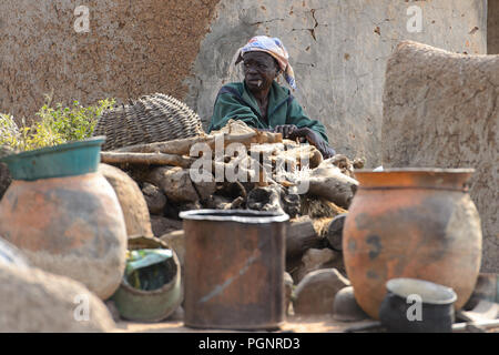 GHANI, GHANA - Jan 14, 2017: in Ghana non identificato uomo vecchio fuma vicino alla casa di Ghani village. Il Ghana di persone soffrono di povertà a causa della cattiva e Foto Stock