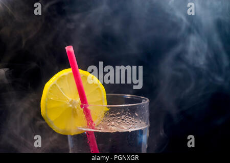 Limonata Fresca, limone e cannuccia con fumo isolati su sfondo nero Foto Stock