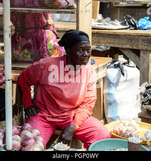 KUMASI, GHANA - Jan 15, 2017: Unidentified ghanesi vecchia donna vende merci al mercato di Kumasi. Il Ghana di persone soffrono di povertà a causa della cattiva economia. Foto Stock