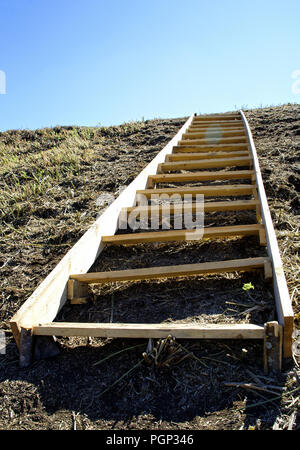Un maldestro scaletta di legno che giace su una collina di terracotta. Conceptual-movimento up steep scomodo passi, business, creatività e sviluppo umano Foto Stock