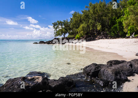 Oceano Blu e nero pietre di lava su di una spiaggia di sabbia di lava vulcanica isola Maurizio Foto Stock