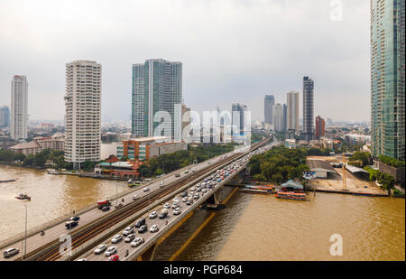 Occupato Krung Thon Buri Road, re Taksin ponte sopra il fiume Chao Phraya, iconico grattacieli dalla Cisgiordania Khlong San district, Bangkok, Thailandia Foto Stock