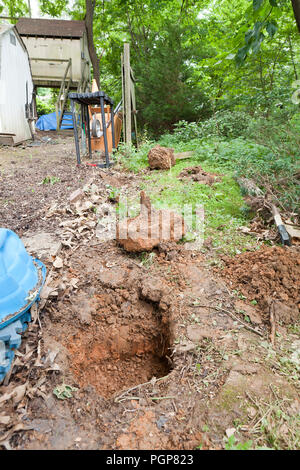 Palo da recinzione di fori nel terreno durante le riparazioni di recinzione - USA Foto Stock