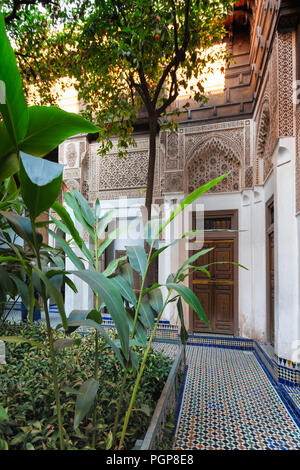 Stile marocchino. Interno cortile piastrellato giardino con piante e alberi tropicali. Posizione: Marrakech Foto Stock