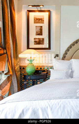 La camera da letto di lusso stile marocchino con biancheria bianca e finestra di seta di trattamento. Piastrelle in mosaico gli accenti. Camera elegante decor. Foto Stock