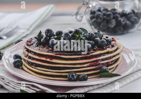 Una delizia prima colazione con frutta fresca su party in giardino, al di fuori di fiori dietro e erbe aromatiche fresche sulla parte superiore Foto Stock