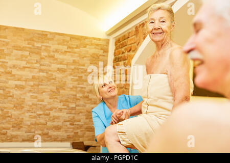 Bagni senior con cura nella jacuzzi del centro termale in una terapia acquatica Foto Stock