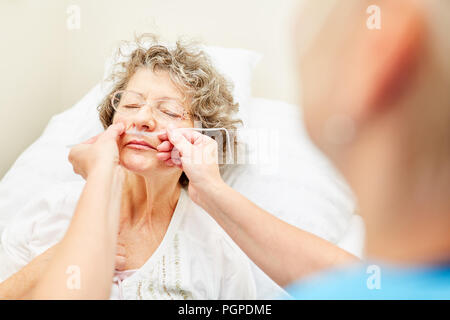 Malati senior con tubo nasogastrico per la nutrizione artificiale o per l'ossigeno Foto Stock