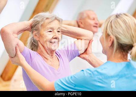 Trainer aiuta gli anziani con schiena sana formazione in fisioterapia Foto Stock