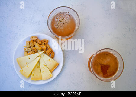 Due bicchieri di birra, formaggio e cracker, centro, vista da sopra Foto Stock