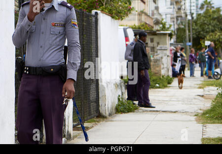 L'Avana, Cuba. Xvii gen, 2014. Un governo guardia di sicurezza cammina per la strada mentre il pattugliamento di fronte all ambasciata all'Avana. Non molto è cambiato per la classe media di Cuba. Essi vivono ancora in un isolato, limitando il governo, società comunista. Mentre alcuni nuovi servizi moderni come la connessione wifi hanno fatto il loro modo a Cuba la maggior parte dei cubani non possono permettersi di utilizzare regolarmente. Credito: Allison cena/ZUMA filo/Alamy Live News Foto Stock