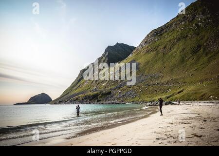 Haukland Beach, Lofoten, Norvegia. 28 Agosto 2018: le persone godono di un bagno a Haukland spiaggia, su una soleggiata giornata cloufless a Lofoten, Norvegia. Questo stile carribean Beach è situato all'interno del circolo polare artico. L'arcipelago di esperienze di uno dei più grandi del mondo a temperatura elevata di anomalie rispetto alla sua alta latitudine. Credito: Matthias Oesterle/Alamy Live News Foto Stock