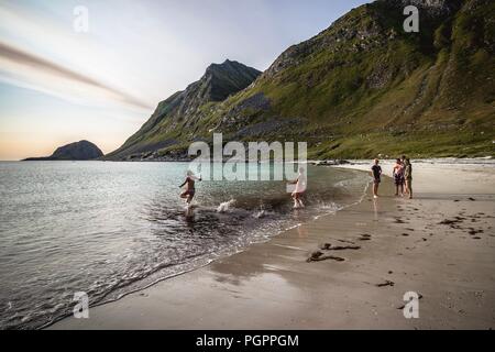 Haukland Beach, Lofoten, Norvegia. 28 Agosto 2018: le persone godono di un bagno a Haukland spiaggia, su una soleggiata giornata cloufless a Lofoten, Norvegia. Questo stile carribean Beach è situato all'interno del circolo polare artico. L'arcipelago di esperienze di uno dei più grandi del mondo a temperatura elevata di anomalie rispetto alla sua alta latitudine. Credito: Matthias Oesterle/Alamy Live News Foto Stock