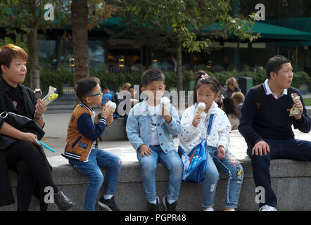 Londra, UK, 28 agosto 2018,una famiglia asiatica sedersi e mangiare gelati in Queens a piedi dal fiume Tamigi su un giorno d'estate nonostante i cieli grigi. Credito Larby Keith/Alamy Live News Foto Stock