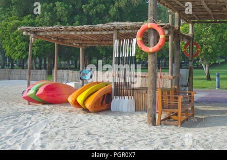 Massa plastica prodotti kayaks di vari colori sono affittati sul mare spiaggia sabbiosa. Mattina su Dubai città mare spiaggia Foto Stock