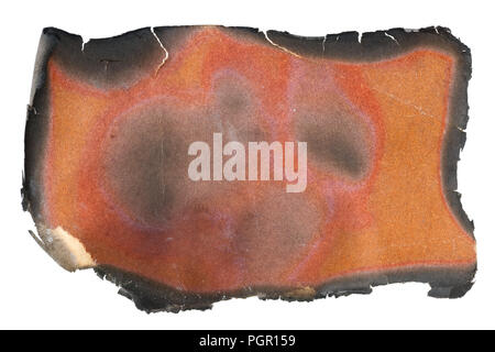 A small piece of a glossy magazine red page burnt in the fire concept. Isolated on white studio macro Foto Stock
