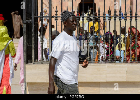 TOUBA, SENEGAL - Apr 26, 2017: Non identificato uomo senegalese passeggiate nella grande moschea di Touba, sede della Confraternita Mouride Foto Stock