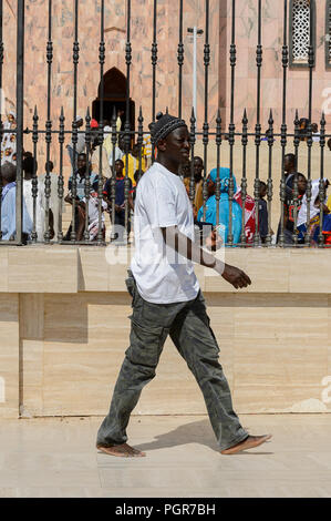 TOUBA, SENEGAL - Apr 26, 2017: Non identificato uomo senegalese passeggiate nella grande moschea di Touba, sede della Confraternita Mouride Foto Stock