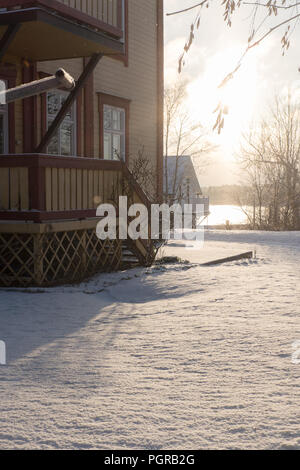 Legno casa svedese in inverno durante il sun dawn, situato in skerries vicino a Stoccolma Foto Stock