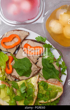 Preparati freschi fette di pane e panini fatti in casa con sgombro o tonno e fegato di maiale pasta, lattuga, prezzemolo, Toast con pasta di avocado e o Foto Stock