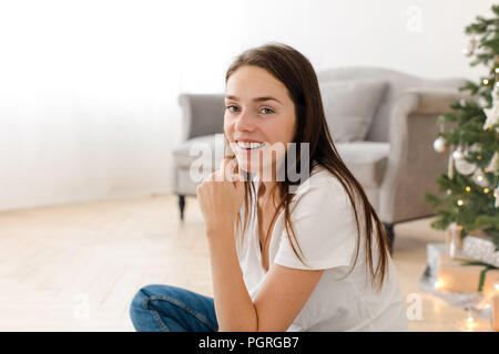 Casual giovane donna a casa in tempo di Natale Foto Stock