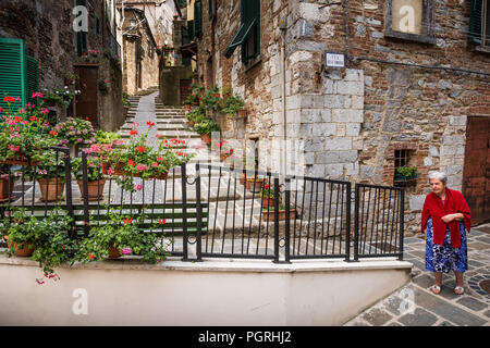 Montieri, Grosseto, Toscana - antico borgo, donna sconosciuta passeggiate sulle tipiche stradine strette e costruzioni di pietra Foto Stock