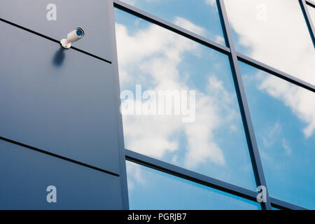 La facciata in vetro dell'ufficio moderno edificio con una telecamera di sicurezza Foto Stock