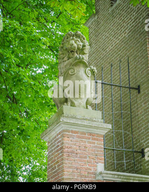 Leone di pietra statua su un palo di mattoni Foto Stock