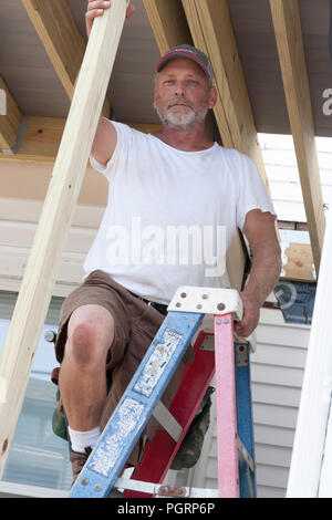 Carpenter ritratto, in piedi su una scala. Foto Stock