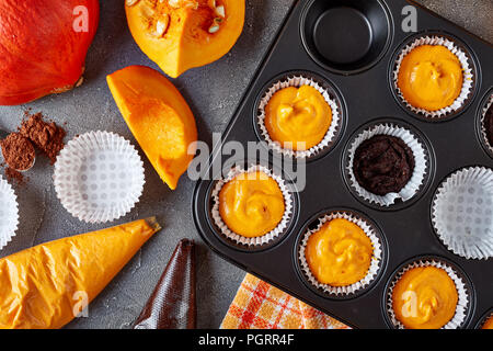 Rendendo la zucca muffin al cioccolato per la festa di Halloween. ingredienti in background, vista da sopra, close-up Foto Stock