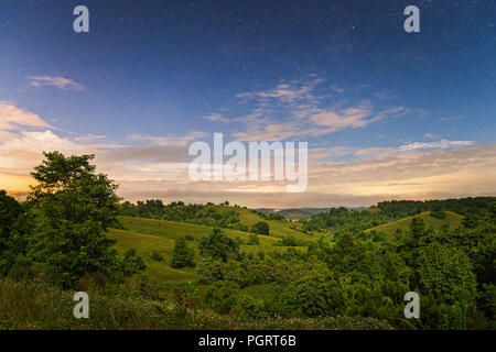 Luna e star light evidenziare le dolci colline del paese lato lungo il fiume Kanawha Valley a Henderson, West Virginia. Foto Stock