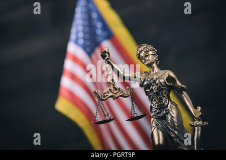 Il diritto e la giustizia, il concetto di legalità, bilancia della giustizia, Lady giustizia davanti alla bandiera americana in background. Foto Stock