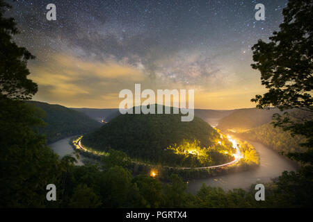 In un inizio di primavera notte la Via Lattea si vede innalzarsi al di sopra delle montagne del New River Gorge in West Virginia, oltre la piccola città di Thurmond. Foto Stock