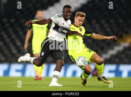 Fulham's Ibrahima Cisse (sinistra) e Exeter City's Archie Collins (a destra) battaglia per la sfera durante il Carabao Cup, secondo round corrispondono a Craven Cottage, Londra. Foto Stock