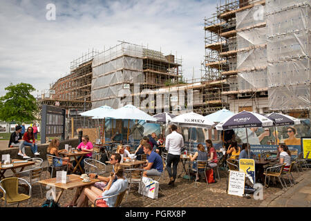 Regno Unito, Inghilterra, Devon, Exeter Cathedral Yard, pavement cafe tabelle nella parte anteriore del fuoco danneggiato Royal Clarence Hotel Foto Stock