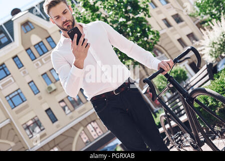 Persone, comunicazione, tecnologia, del tempo libero e dello stile di vita - hipster uomo con lo smartphone su fixed gear bike chat telefono Foto Stock