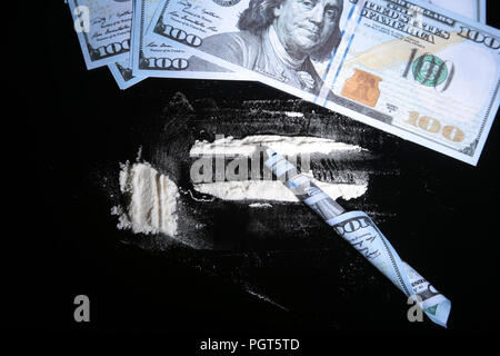 La cocaina farmaci mucchio ancora in vita su uno specchio con laminati 100 dollar banconota, in primo piano. Foto Stock