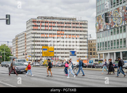 Le persone che attraversano le Otto-Braun Strasse vicino Alexanderplatz con la Haus der Statistik in background, Berlino, Germania Foto Stock