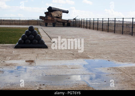 Un cannone e le palle di cannone in batteria a salve a La Valletta Foto Stock