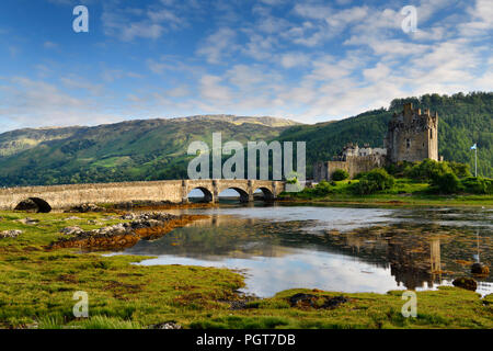 Luce della Sera il restaurato castello Eilean Donan con Sun su aggiunto arco in pietra passerella per l'isola in Highlands scozzesi Scotland Regno Unito Foto Stock