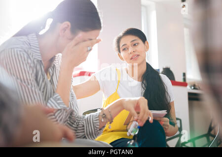 Psicologo affidabile gentilmente guardando il pianto della donna durante la sessione Foto Stock