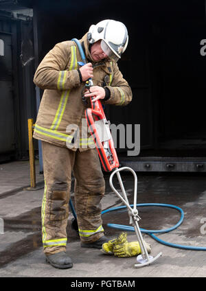 Paul Halliday, responsabile degli orologi dei vigili del fuoco dello Scottish Fire and Rescue Service, presso il National Training Center di Glasgow, dimostra una lancia ad altissima pressione, denominata "Coldcut Cobra", che consentirà ai vigili del fuoco di far esplodere un agente antincendio attraverso il muro di un edificio in fiamme. Foto Stock