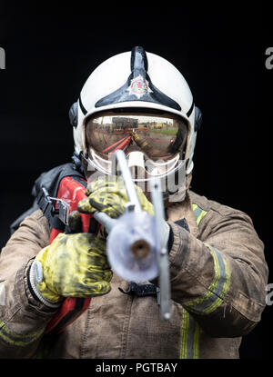 Paul Halliday, direttore dell'orologio dei vigili del fuoco dello Scottish Fire and Rescue Service, presso il National Training Center di Glasgow, dimostra una lancia ad altissima pressione, con il marchio Coldcut Cobra, che consentirà ai vigili del fuoco di soffiare un soppressore di incendi attraverso il muro di un edificio in fiamme. Foto Stock