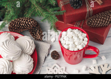 Natale ancora in vita con zephyr o meringa e e una tazza di una bevanda calda con marshmallow sul tavolo. Festive abete e decorazioni Foto Stock