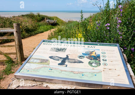 Una scheda interpretativa sul percorso verso la spiaggia e il mare a Brook Bay sull'Isola di Wight. Foto Stock