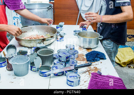 QUITO, ECUADOR, Agosto 21, 2018: la gente in cucina cucina la cena e aprire molte tonno può, all'interno di un rifugio per il popolo venezuelano che sfuggito fr Foto Stock