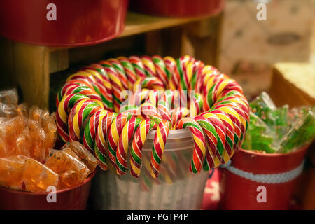 Mercatino di Natale di colore rosso brillante lecca-lecca, caramelle, sulla finestra del negozio di supermercato, mercato Foto Stock